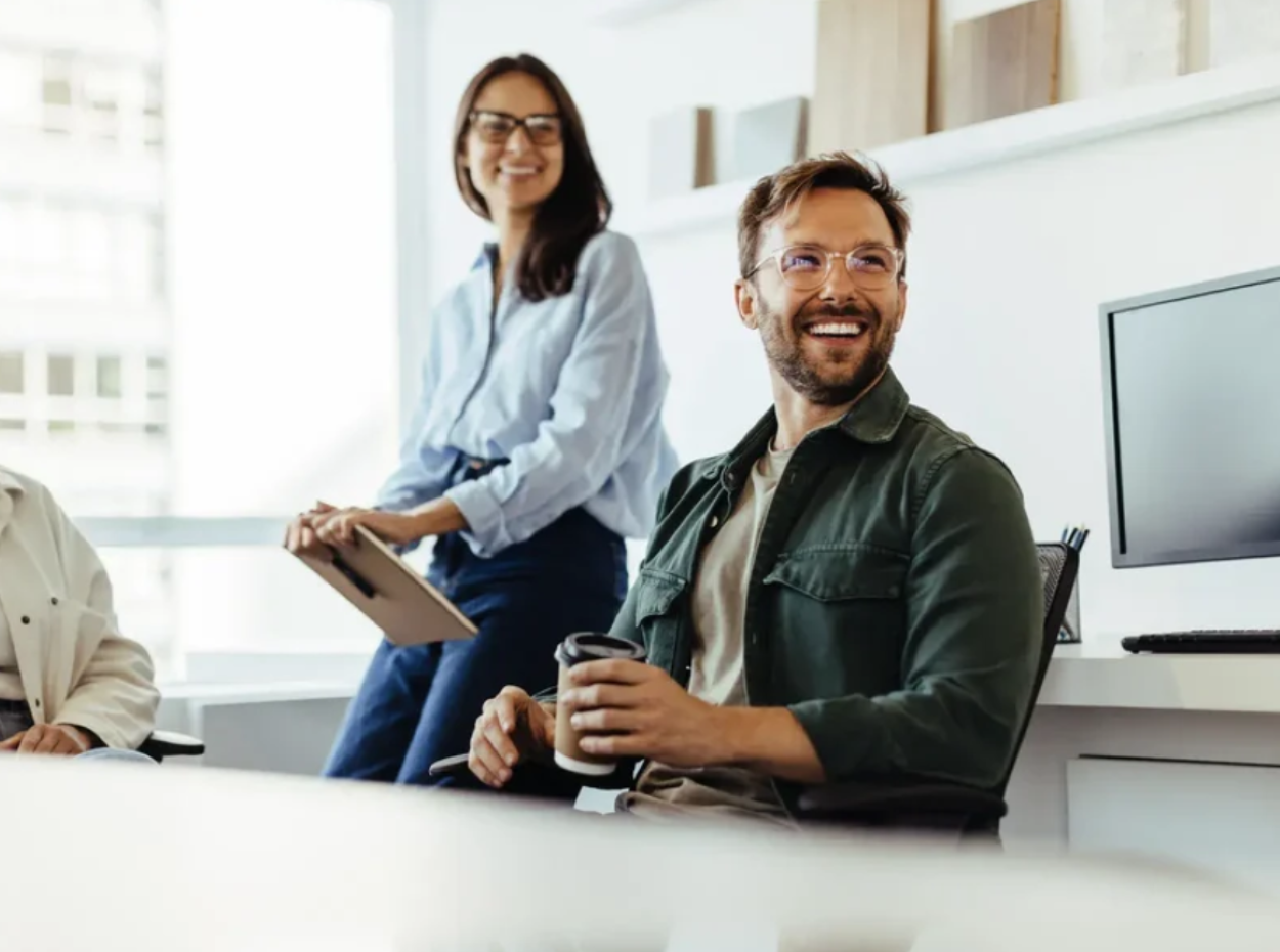 Man and woman office setting smiling