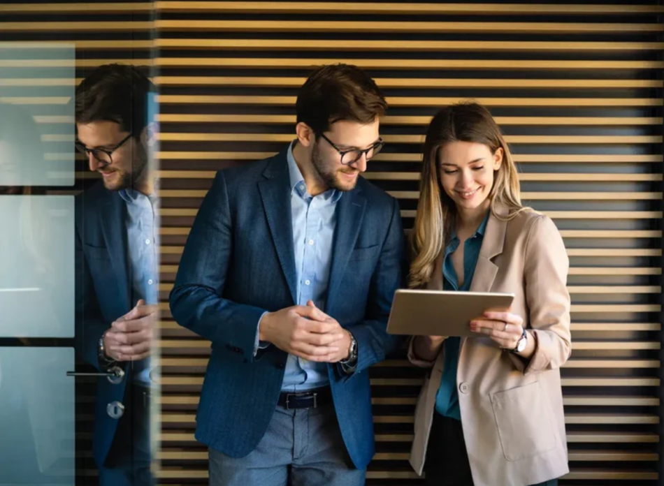 Man and woman standing looking at laptop-1