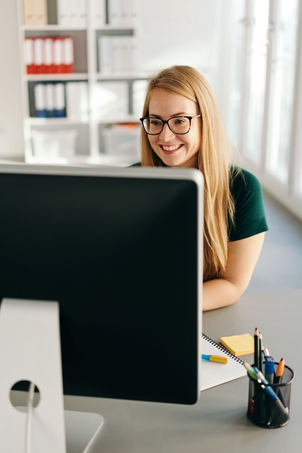woman smiling at a computer